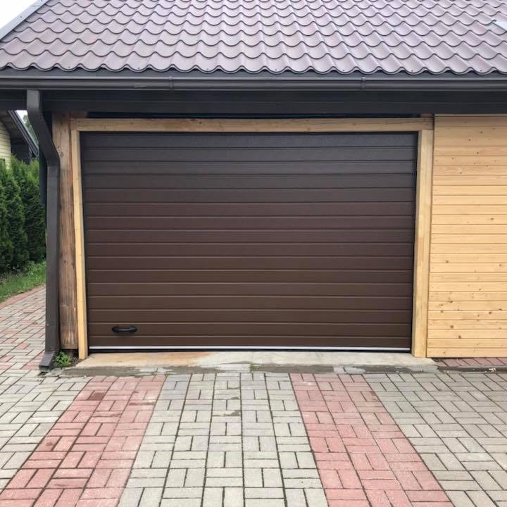 dark brown ribbed panels garage doors private garage brick driveway 